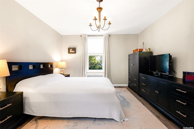 bedroom with hardwood / wood-style floors and an inviting chandelier