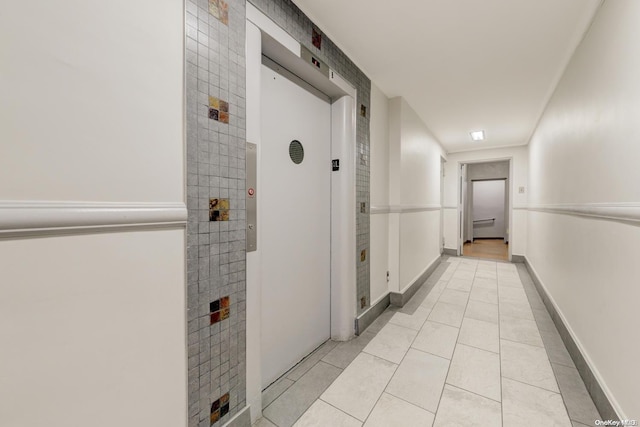 hall with light tile patterned floors and elevator