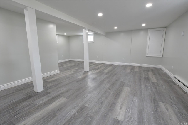 basement featuring hardwood / wood-style flooring and a baseboard heating unit