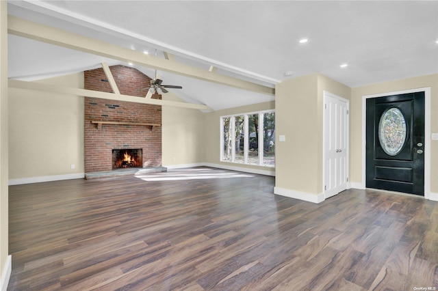 entryway featuring lofted ceiling with beams, a brick fireplace, ceiling fan, and dark wood-type flooring