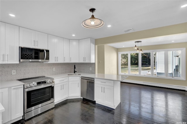 kitchen with kitchen peninsula, appliances with stainless steel finishes, white cabinetry, and hanging light fixtures