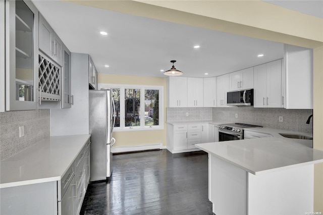 kitchen featuring stainless steel appliances, dark wood-type flooring, sink, pendant lighting, and white cabinets