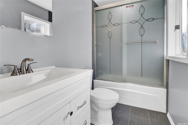 full bathroom featuring vanity, toilet, and combined bath / shower with glass door