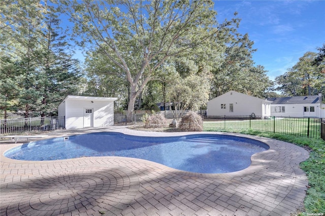 view of pool featuring an outbuilding, a patio, and a diving board