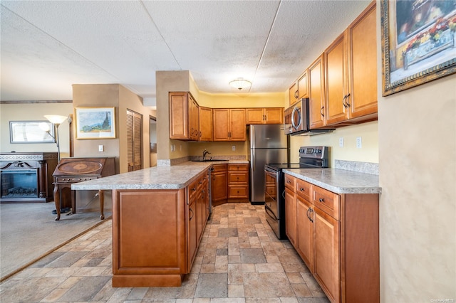 kitchen with kitchen peninsula, a kitchen breakfast bar, a textured ceiling, stainless steel appliances, and sink