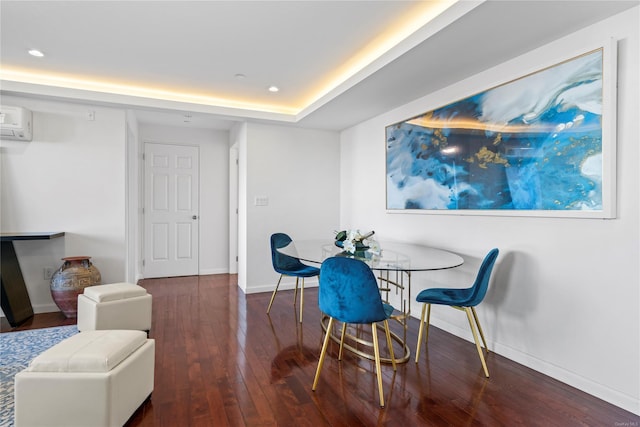 dining space featuring a wall mounted air conditioner, dark wood-type flooring, and a tray ceiling