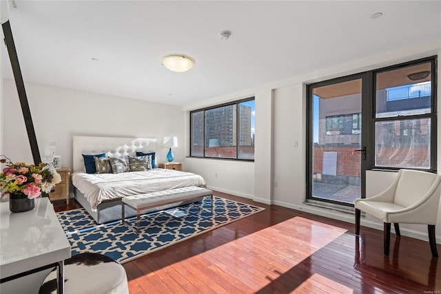 bedroom with dark hardwood / wood-style flooring and multiple windows