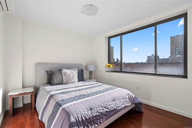 bedroom featuring dark hardwood / wood-style flooring and an AC wall unit