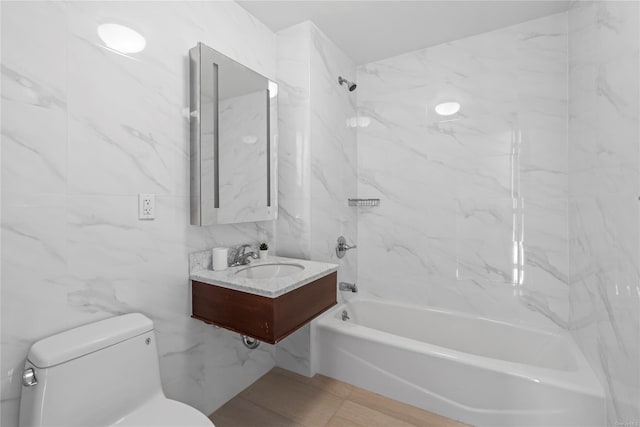 full bathroom featuring tile walls, sink, tiled shower / bath combo, and toilet