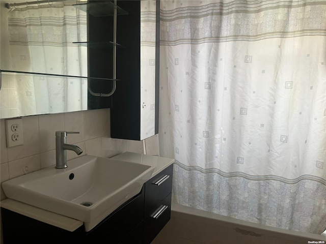 bathroom with vanity and tasteful backsplash