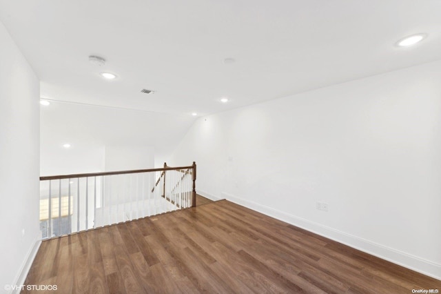 unfurnished room with lofted ceiling and wood-type flooring