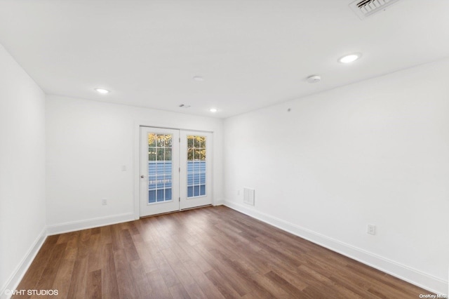 empty room with hardwood / wood-style flooring and french doors