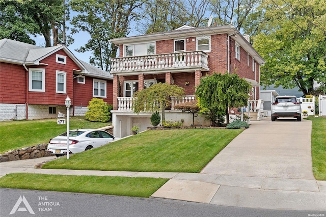 view of front of house featuring a balcony and a front lawn