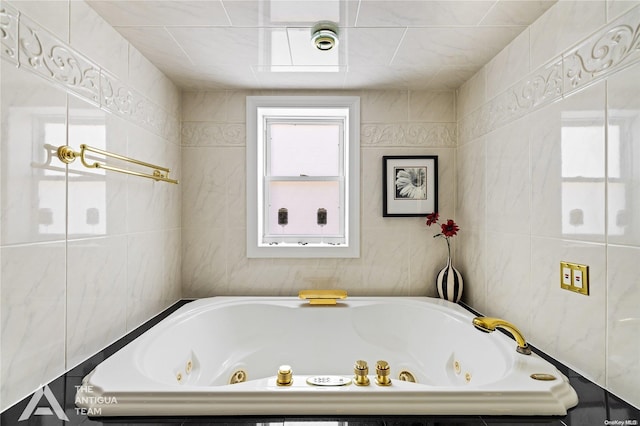 bathroom featuring a relaxing tiled tub and tile walls