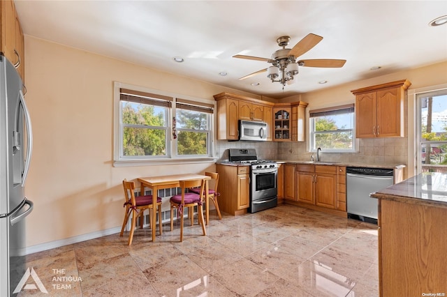 kitchen featuring backsplash, ceiling fan, sink, and appliances with stainless steel finishes