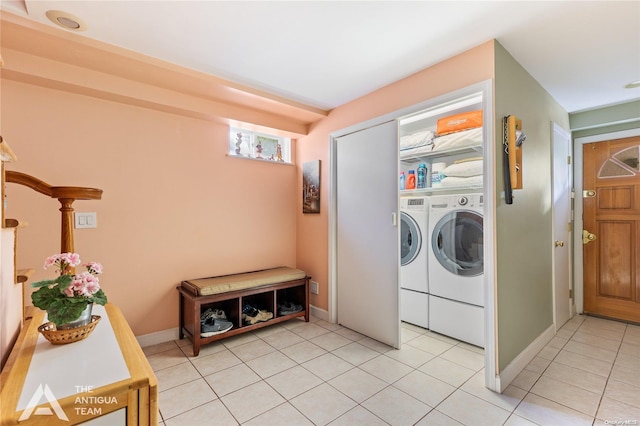 laundry area with washing machine and dryer and light tile patterned floors