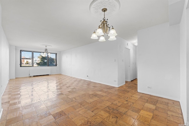 empty room featuring radiator and an inviting chandelier