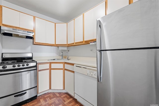 kitchen featuring white cabinets, dark parquet flooring, stainless steel appliances, and sink