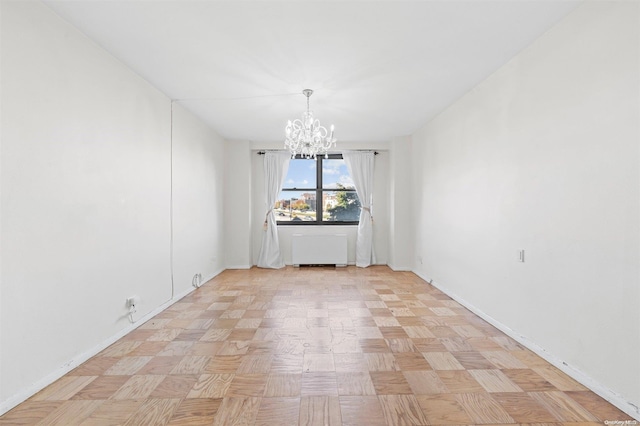 unfurnished room with radiator heating unit, light parquet floors, and a notable chandelier