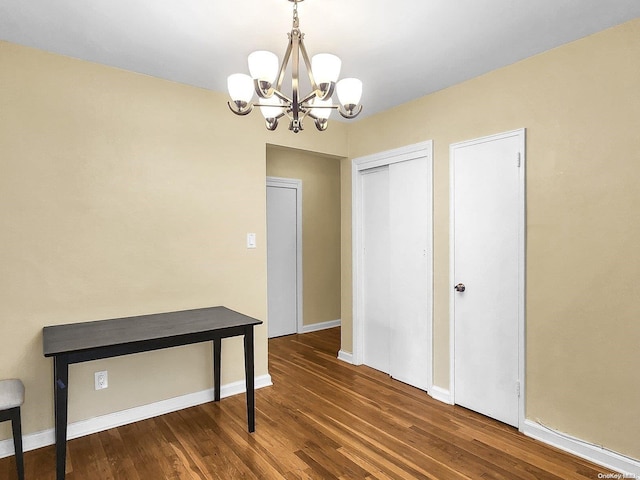 interior space featuring dark wood-type flooring and an inviting chandelier