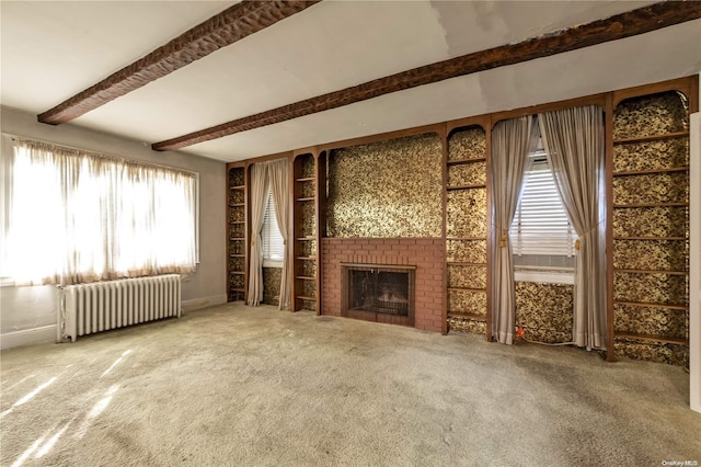 unfurnished living room with a fireplace, radiator heating unit, a healthy amount of sunlight, and carpet