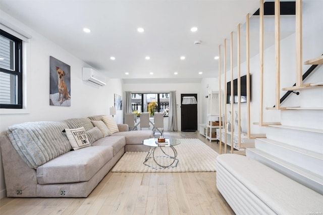 living room featuring an AC wall unit and light wood-type flooring