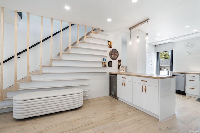 stairs with wood-type flooring and wine cooler