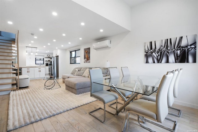 dining room featuring light wood-type flooring, a wall mounted AC, beverage cooler, and sink