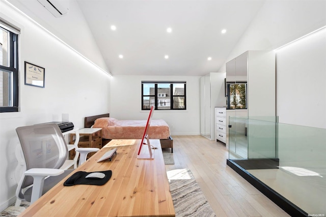 bedroom featuring high vaulted ceiling, light hardwood / wood-style flooring, and a wall unit AC