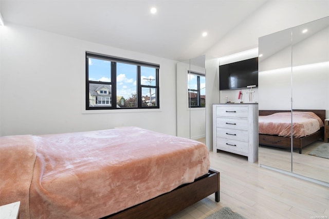 bedroom with light hardwood / wood-style flooring and vaulted ceiling