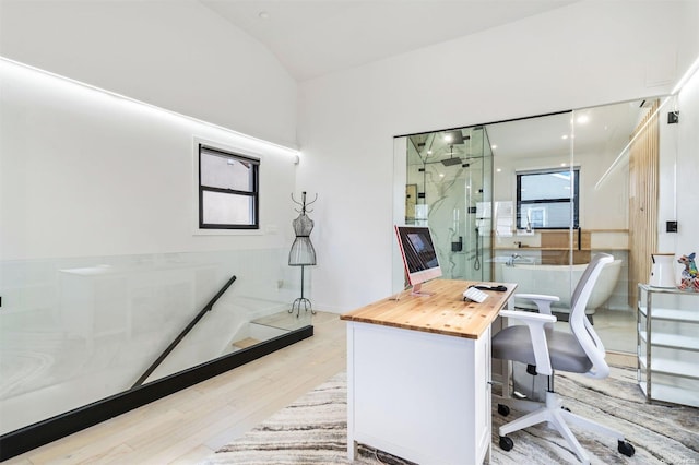 office with lofted ceiling and light wood-type flooring