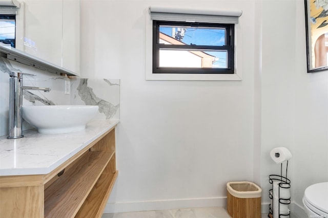 bathroom with vanity, toilet, and decorative backsplash