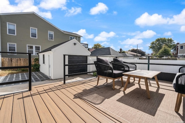 wooden terrace featuring an outbuilding, a patio, and a garage