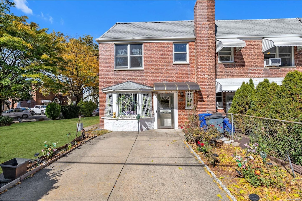 multi unit property featuring cooling unit and a front lawn