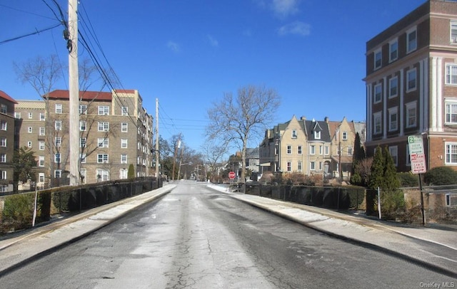 view of street featuring curbs, traffic signs, and sidewalks