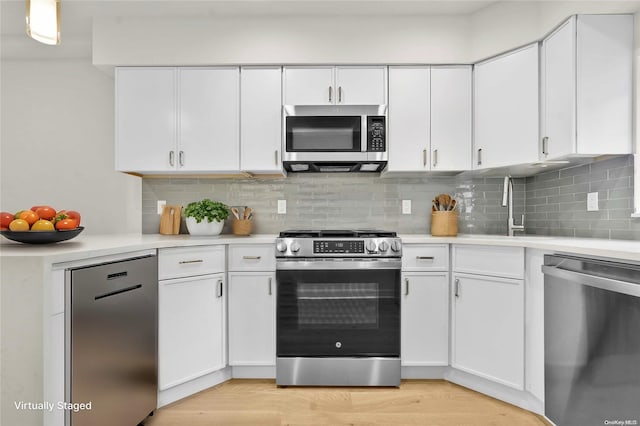 25-25 31st Ave Unit 7B, Astoria, NY 11106 - kitchen featuring appliances with stainless steel finishes, light countertops, white cabinets, and backsplash