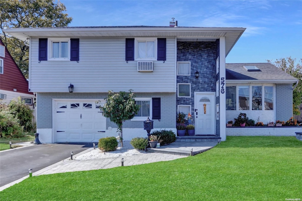 view of front of home featuring a front lawn, a wall mounted air conditioner, and a garage