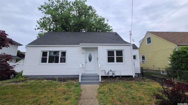 bungalow-style home with a front yard