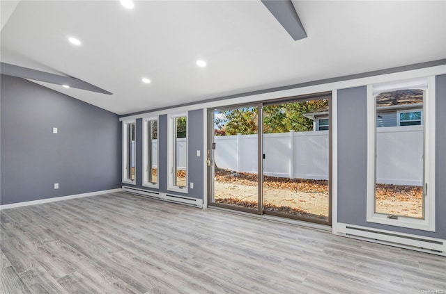 unfurnished room with light wood-type flooring and a baseboard heating unit