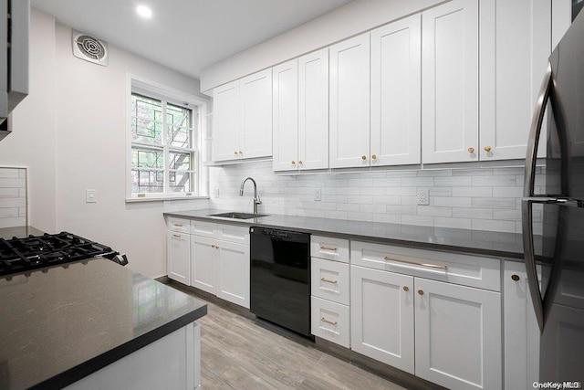 kitchen featuring refrigerator, sink, white cabinets, black dishwasher, and light hardwood / wood-style floors