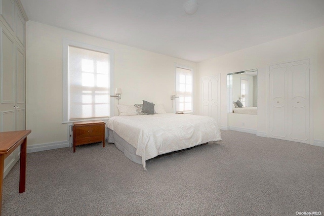 bedroom with light carpet and multiple windows