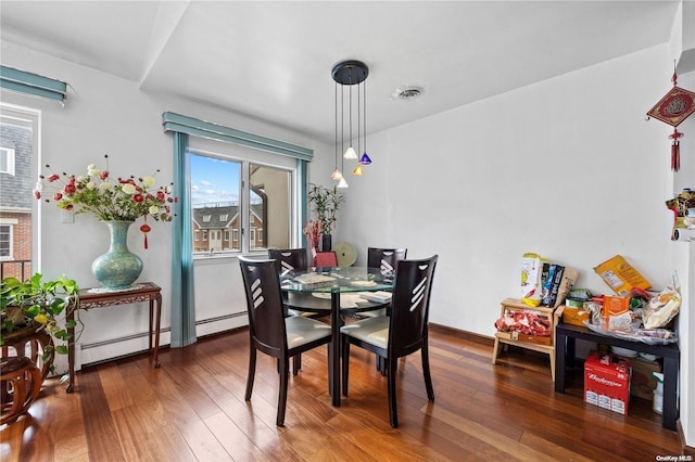 dining area featuring a baseboard heating unit and hardwood / wood-style flooring