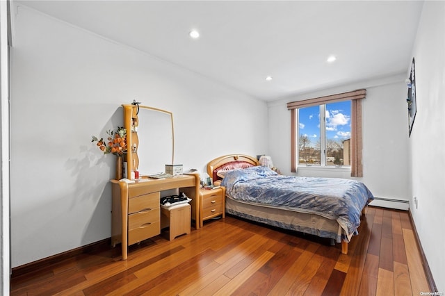 bedroom with dark hardwood / wood-style flooring and baseboard heating