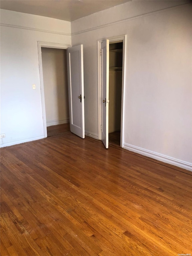 unfurnished bedroom with dark wood-type flooring