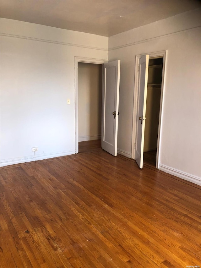 unfurnished bedroom with dark wood-type flooring