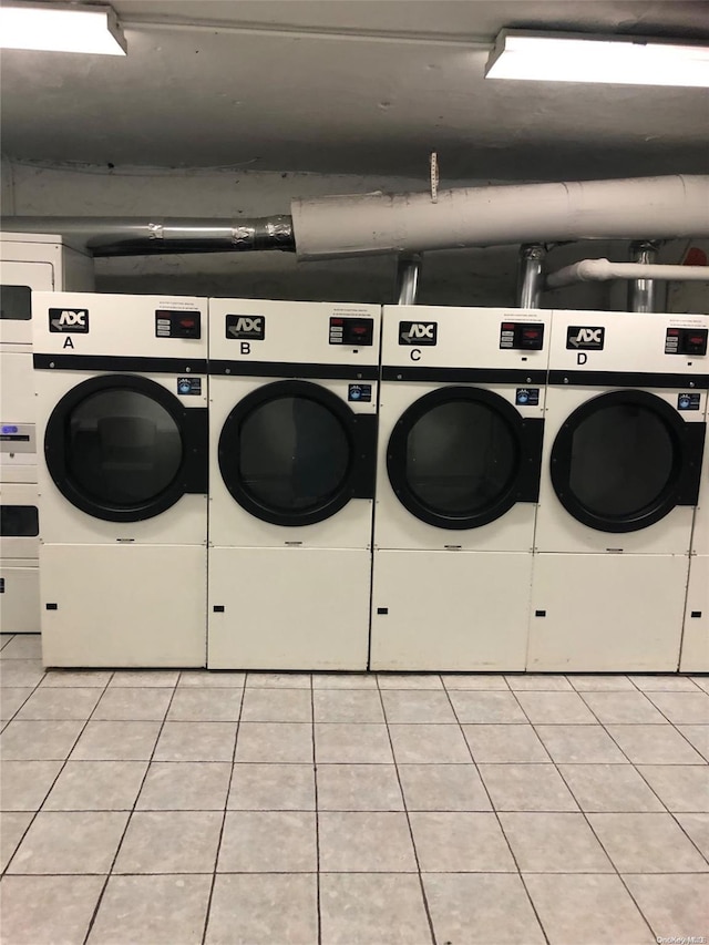 laundry room with washer and clothes dryer and light tile patterned floors