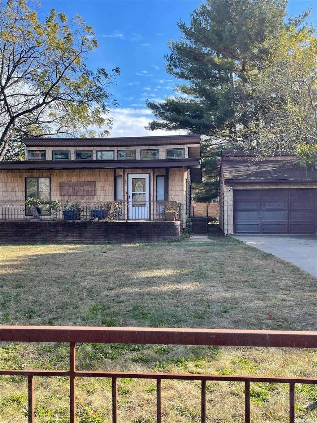 view of front facade with a garage, an outdoor structure, and a front yard