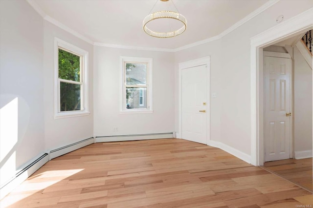 interior space with ornamental molding, a baseboard heating unit, and light wood-type flooring