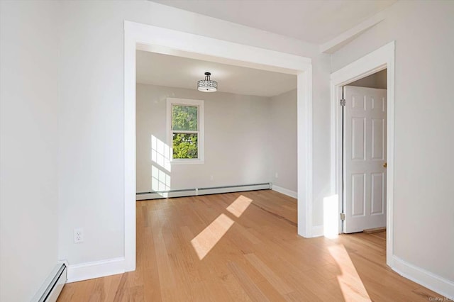 spare room with a baseboard radiator and hardwood / wood-style floors