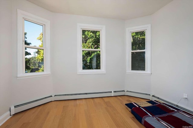 spare room featuring a healthy amount of sunlight and light hardwood / wood-style floors